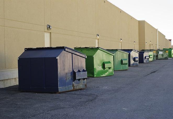 tilted front-load dumpsters being emptied by waste management workers in Creve Coeur